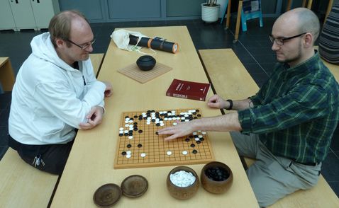 A picture of two persons playing GO
